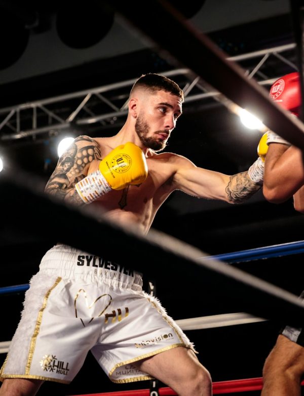 man in white jersey shirt holding yellow bottle