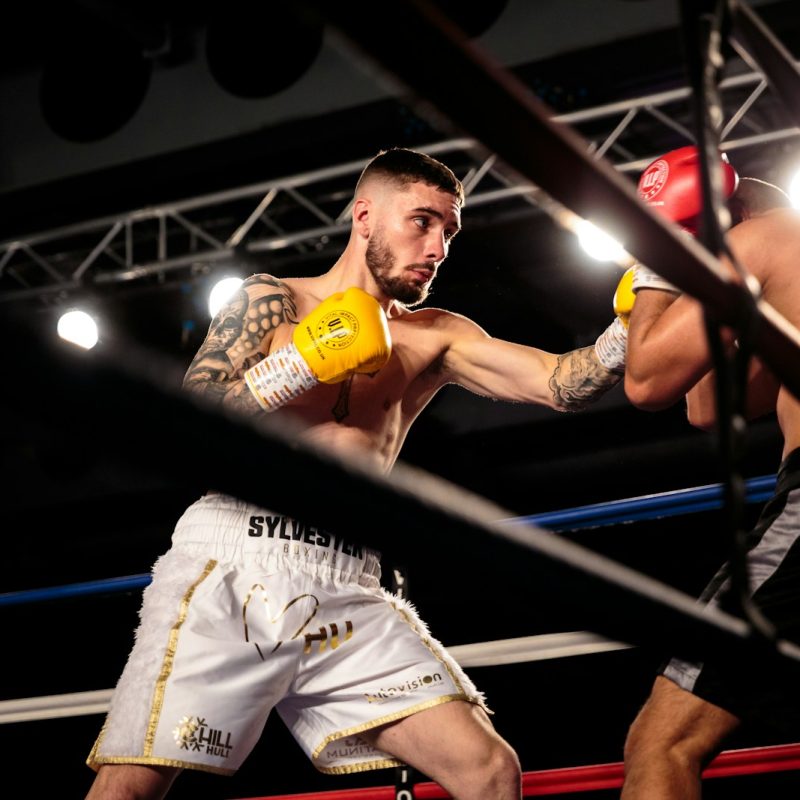 man in white jersey shirt holding yellow bottle